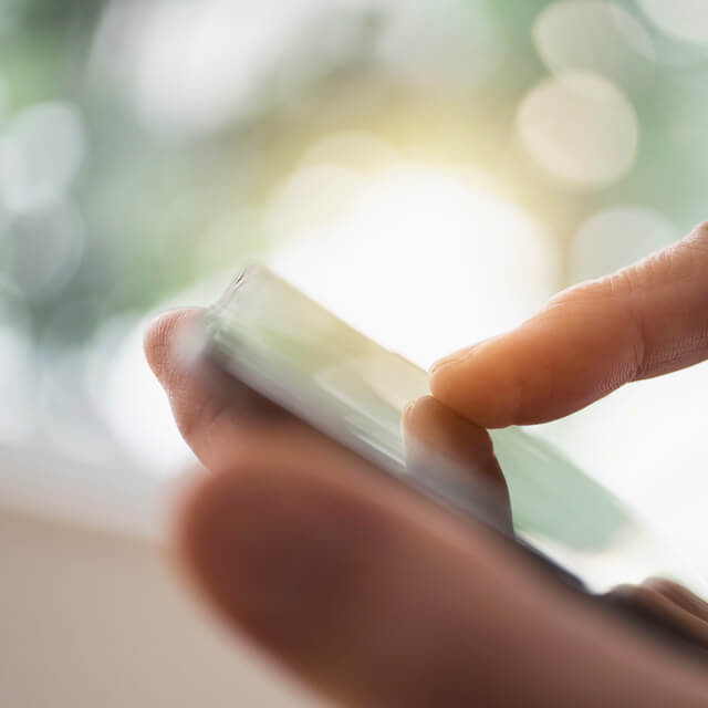 Hombre sosteniendo un teléfono y una tarjeta de crédito