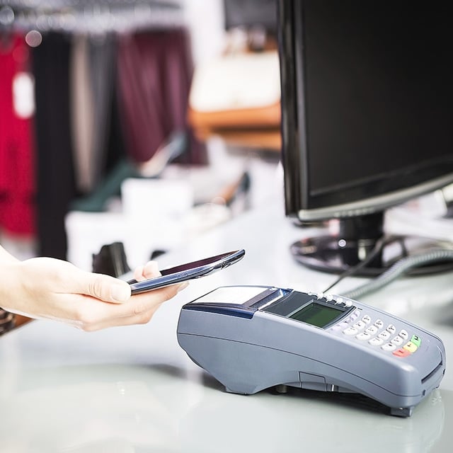 Woman using Apple Pay at checkout.