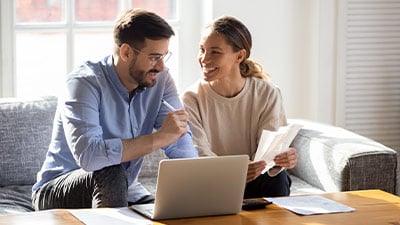 Hombre y mujer sonrientes haciendo un plan de compras