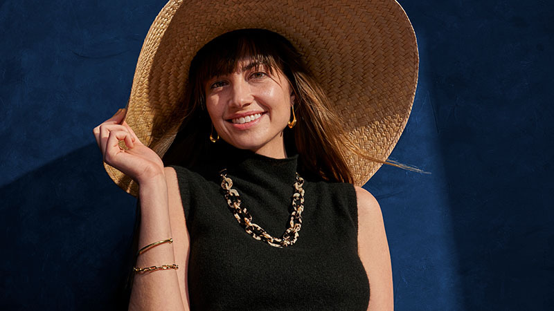 Mujer sonriente son sombrero de ala ancha