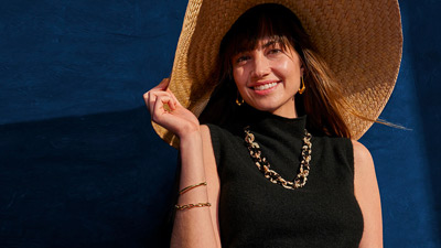 header-infinite-400x225 Mujer sonriente sosteniendo su sombrero de ala ancha