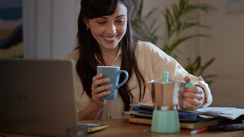 Mujer sonriente con una cafetera
