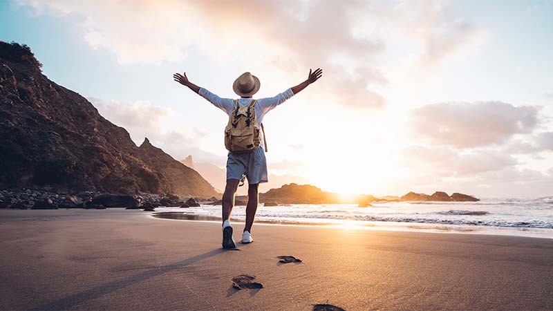 travel-800x450 Hombre disfrutando del amanecer en la playa