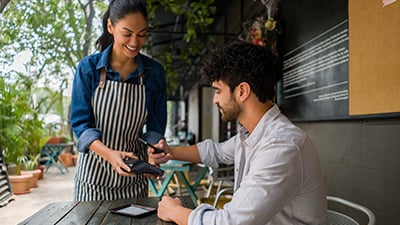 Hombre pagando con su celular en un restaurante